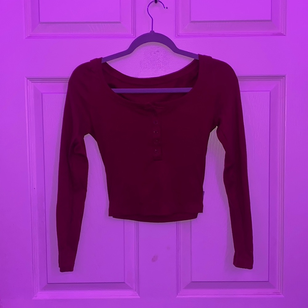 Semi-cropped, dark red, half way button down, tight long sleeve.